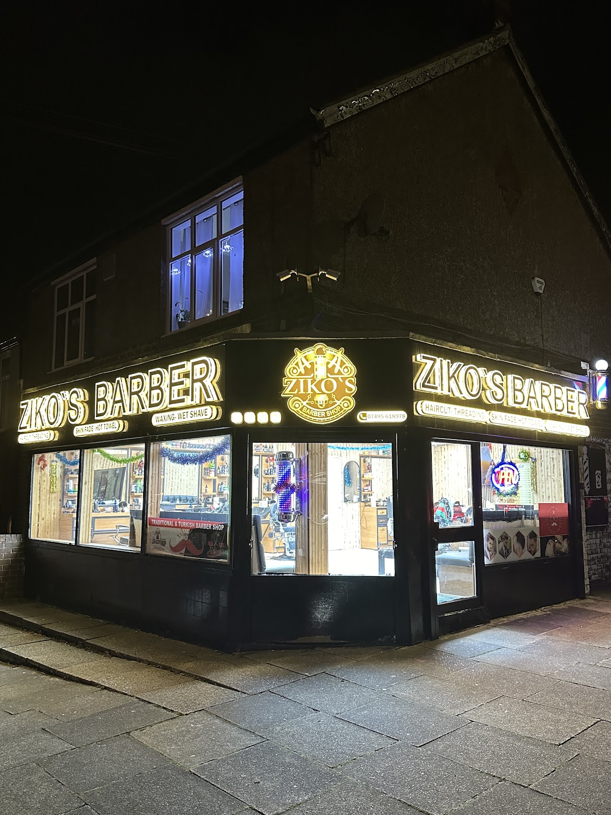 Ziko's Barber Shop illuminated shopfront on Earsdon Road, Whitley Bay at night